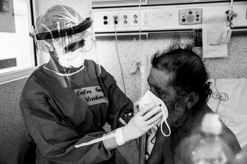 Una enfermera coloca una mascarilla a un paciente