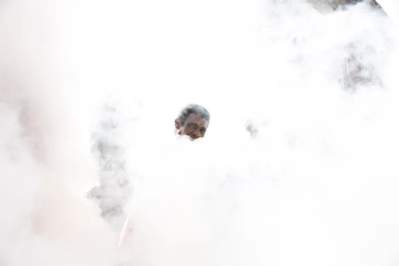 El rostro de un hombre asoma entre una nube de humo blanco