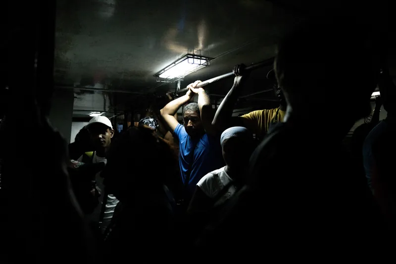 Pasajeros de pie en un autobús casi a oscuras